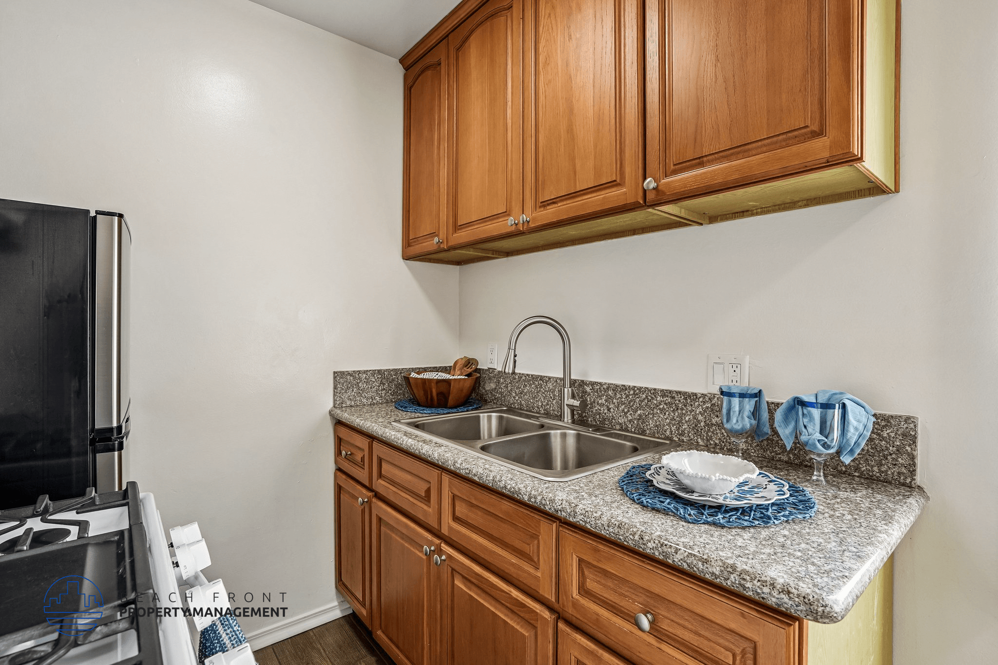 A kitchen with a granite countertop and wooden cabinets.